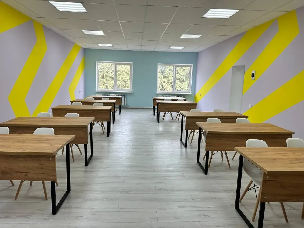 Учебный класс с партами и жёлтыми полосами на стенах