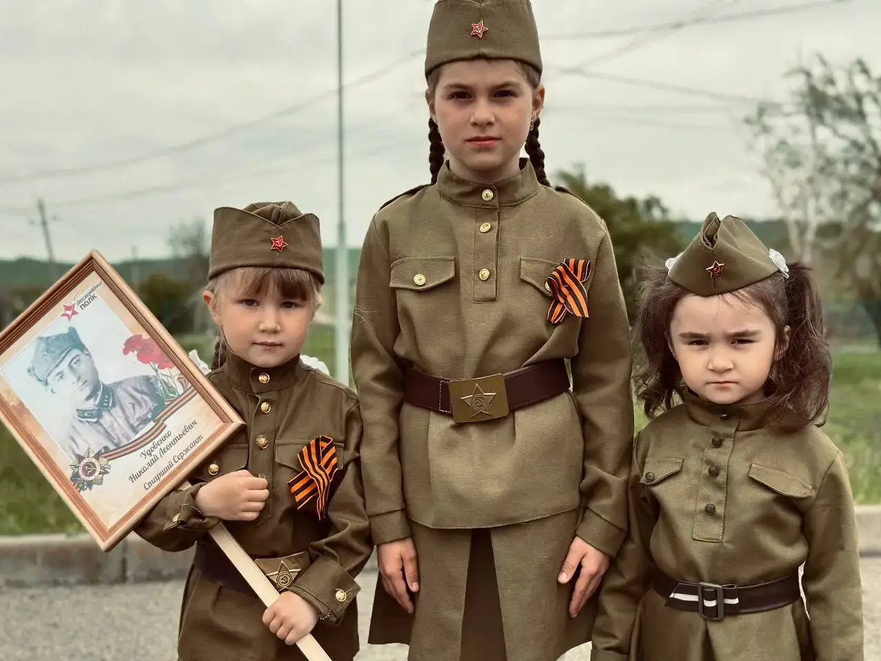 Дети в пилотках с портретом героя